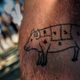 Tattoo of pig diagram on someone's forearm